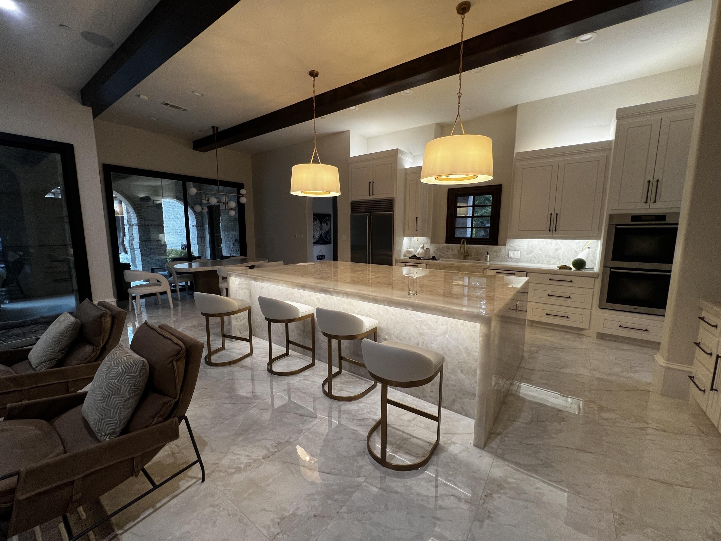 Luxury marble kitchen with layered ambient lighting and an under-counter glow.